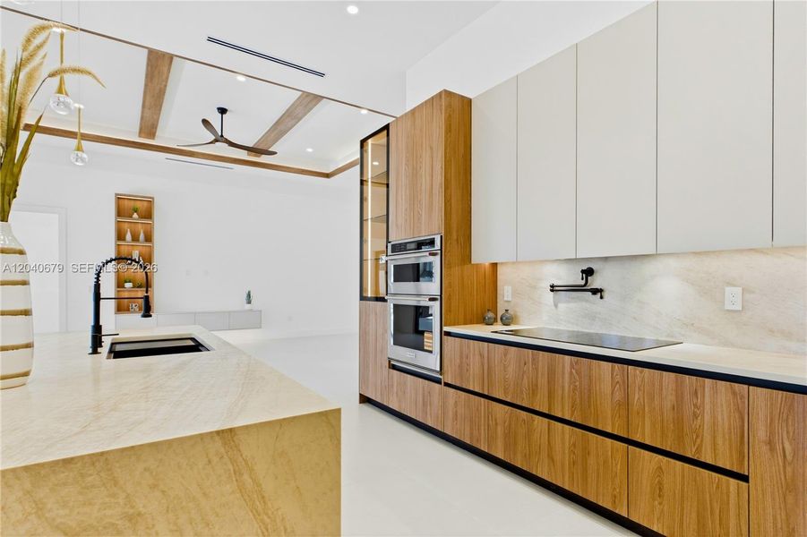 Oversized sink w/ black faucet, pot-filler, wall oven, wall microwave, electric cooktop, dishwasher & French-door refrigerator/freezer