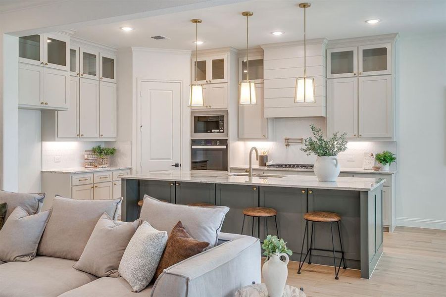 Living area with built in adjustable shelves, light engineered wood flooring, a stone fireplace with solid cedar mantle, ceiling fan, and french doors that open to a covered back patio. Living area with built in adjustable shelves, light engineered wood flooring, a stone fireplace with solid cedar mantle, ceiling fan, and french doors that open to a covered back patio.