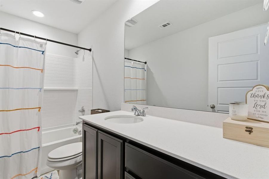 Full bathroom with shower / tub combo with curtain and vanity