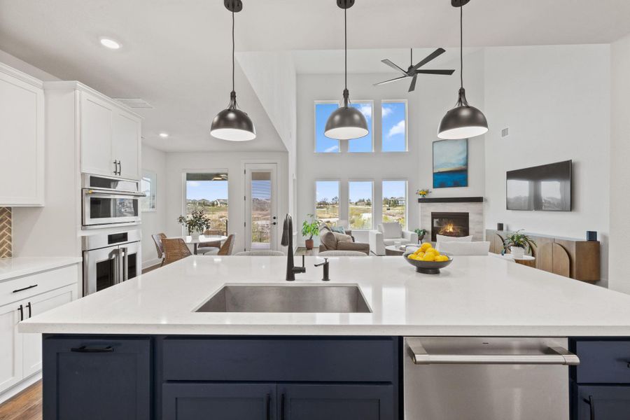 Kitchen with blue cabinetry, stainless steel appliances, white cabinetry, hanging light fixtures, and recessed lighting.