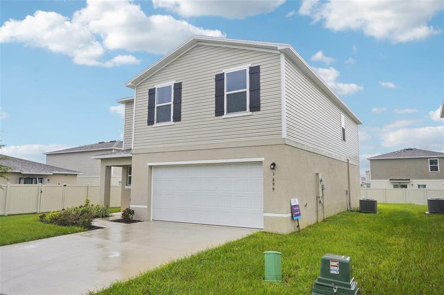 Front exterior of a new home in Scenic Terrace, Haines City, FL, highlighting curb appeal (Image 2). Front exterior of a new home in Scenic Terrace, Haines City, FL, highlighting curb appeal (Image 2).