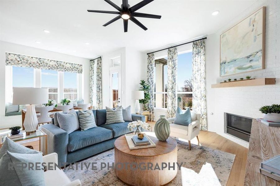 Living room with wood finished floors, a brick fireplace, plenty of natural light, recessed lighting, and a ceiling fan