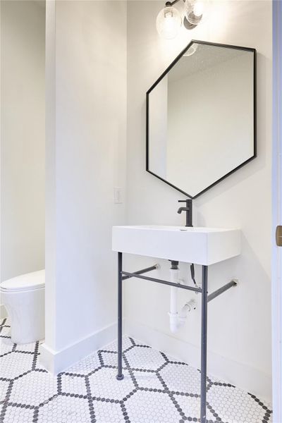 Pool bathroom conveniently located, offers easy outdoor access and featuring a Hive pattern matte porcelain mosaic tile floor.