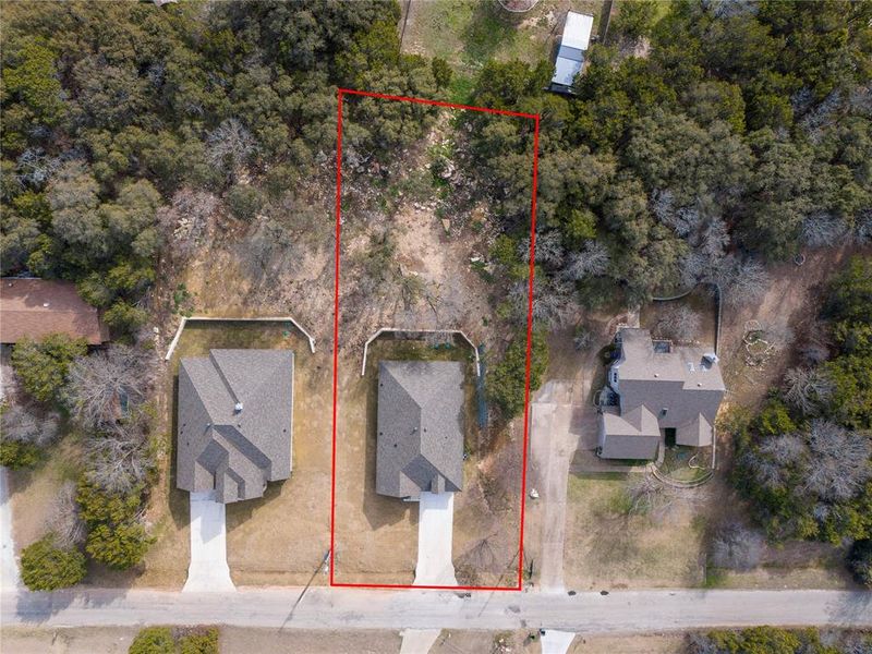 Aerial view showcasing a residential property with a defined red boundary