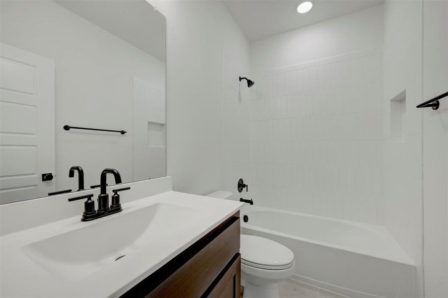Bathroom vanity featuring a single basin, dark wood-finish cabinetry, and matte black fixtures