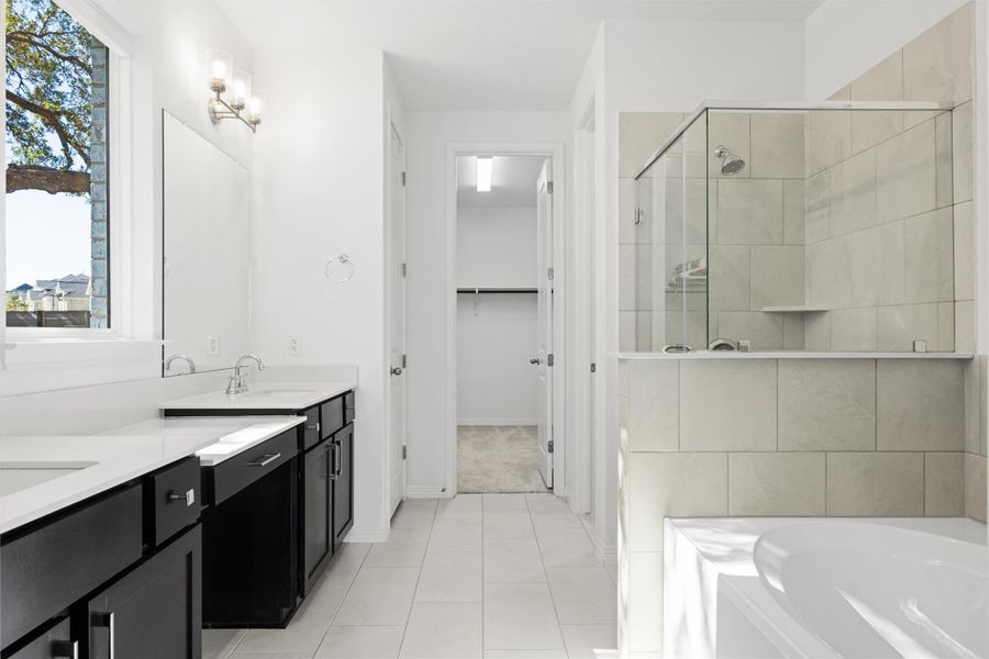 Bathroom with a stall shower, double vanity, light tile patterned flooring, a garden tub, and a spacious closet Bathroom with a stall shower, double vanity, light tile patterned flooring, a garden tub, and a spacious closet