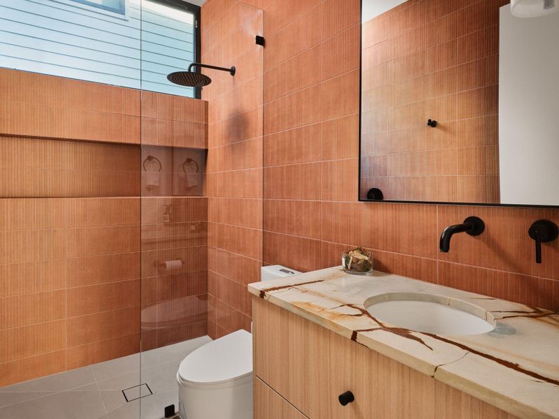 Full bath with a walk in shower, vanity, and tile walls