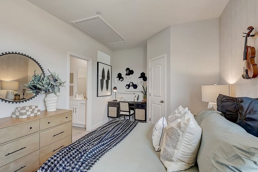 A bedroom with a mirror and a bed.