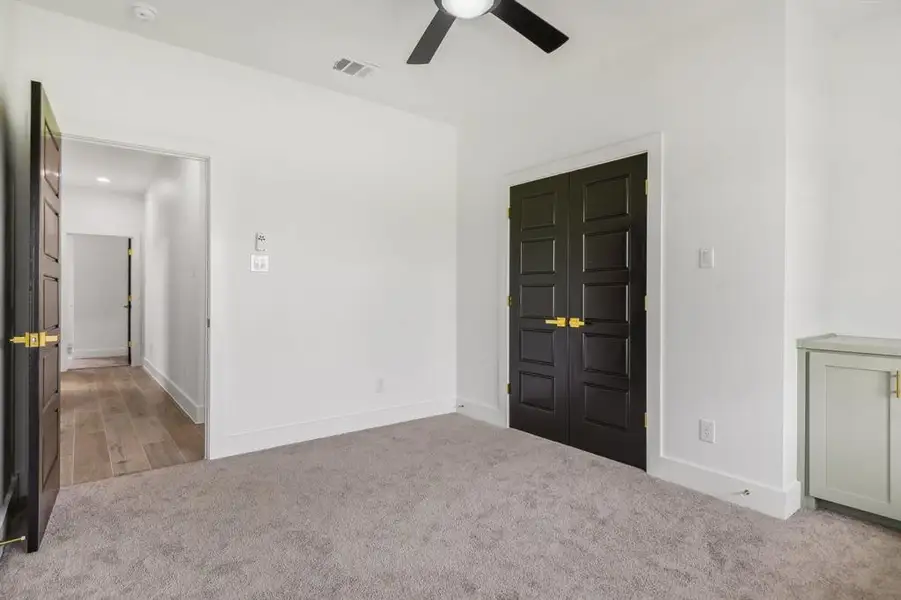 Unfurnished bedroom with light carpet, ceiling fan, and a closet Unfurnished bedroom with light carpet, ceiling fan, and a closet