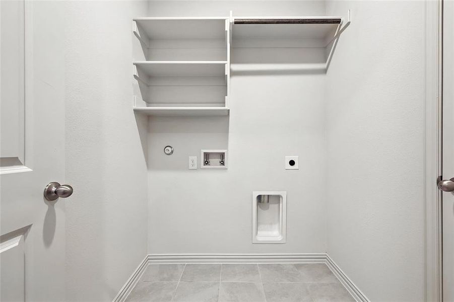 Laundry area featuring gas dryer hookup, washer hookup, hookup for an electric dryer, and tile patterned flooring Laundry area featuring gas dryer hookup, washer hookup, hookup for an electric dryer, and tile patterned flooring