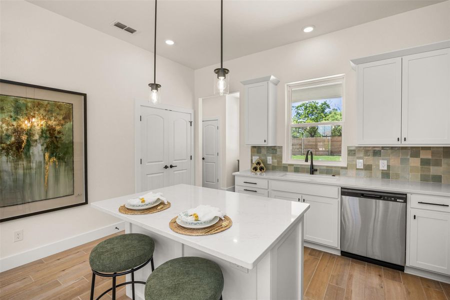A well-appointed kitchen features a central island, recessed lighting, and hardwood flooring.