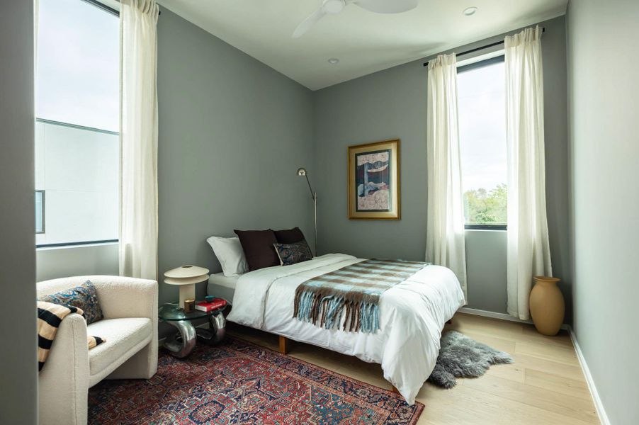 Bedroom 3 upstairs with walk in closet and two large windows.