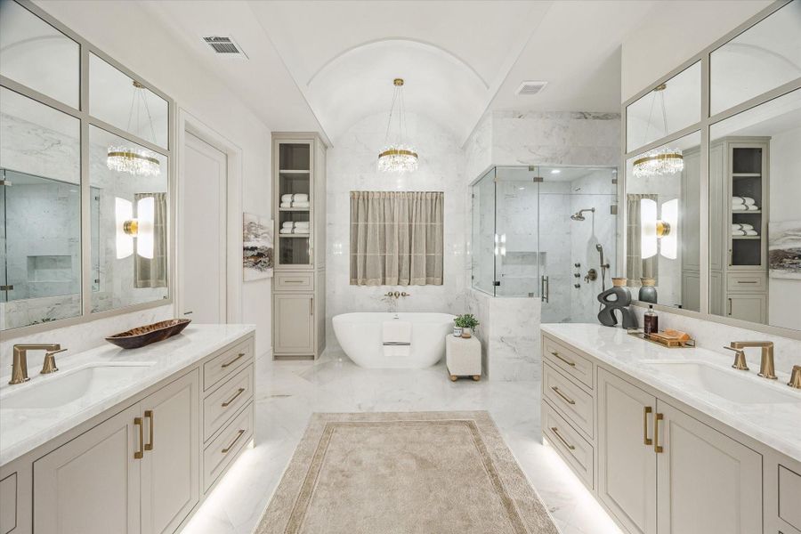 The pristine primary bath has a barreled ceiling centered over the sumptuous soaking tub with crystal chandelier. Large marble floor tiles add elegance. The shower is all marble and features multiple polished gold Brizo sprays. Double vanities make sharing easy!