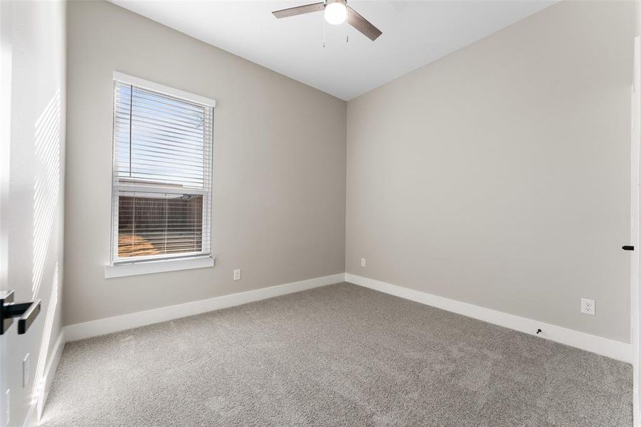 Carpeted empty room featuring ceiling fan