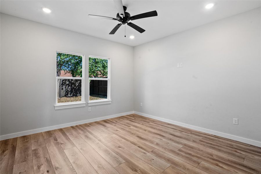 Spare room featuring light wood-style floors, ceiling fan, and recessed lighting
