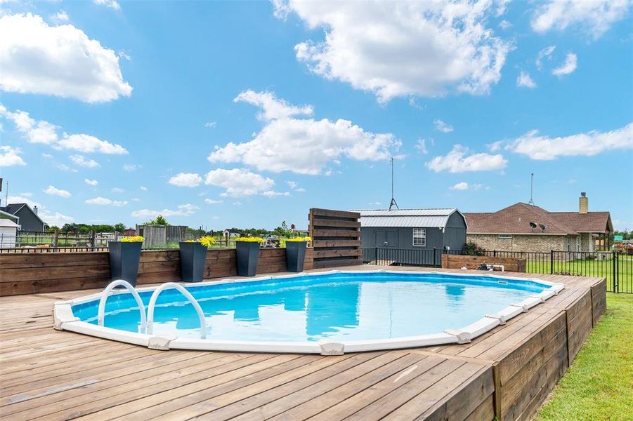 View of pool with a wooden deck