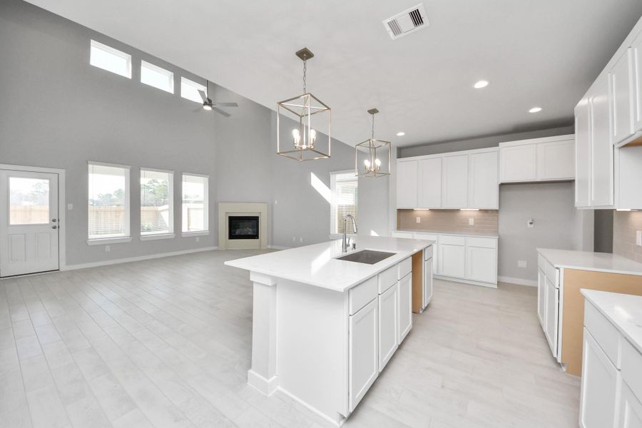 The kitchen is a culinary haven, featuring granite countertops, a tile backsplash, stainless steel appliances, 42” upper cabinets, and undercabinet lighting. Sample photo of completed home with similar floor plan. Actual colors and selections may vary. The kitchen is a culinary haven, featuring granite countertops, a tile backsplash, stainless steel appliances, 42” upper cabinets, and undercabinet lighting. Sample photo of completed home with similar floor plan. Actual colors and selections may vary.