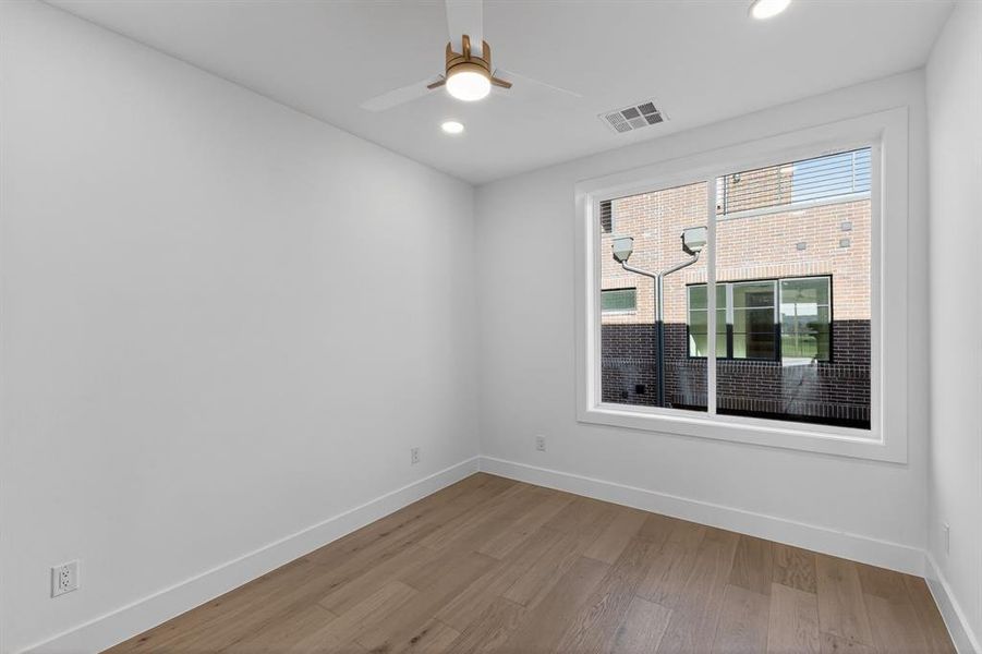Bedroom with light wood-style floors, recessed lighting, and ceiling fan