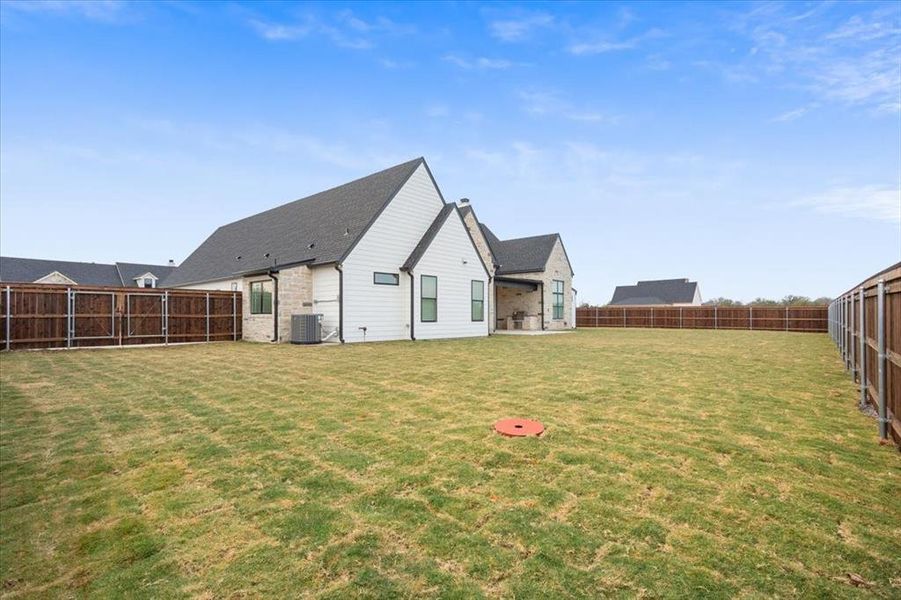 Back of house featuring a fenced backyard, a patio area, and a chimney