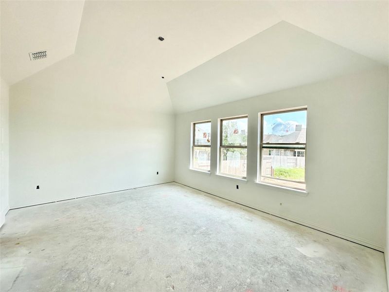 Unfurnished room with vaulted ceiling and unfinished concrete floors Unfurnished room with vaulted ceiling and unfinished concrete floors