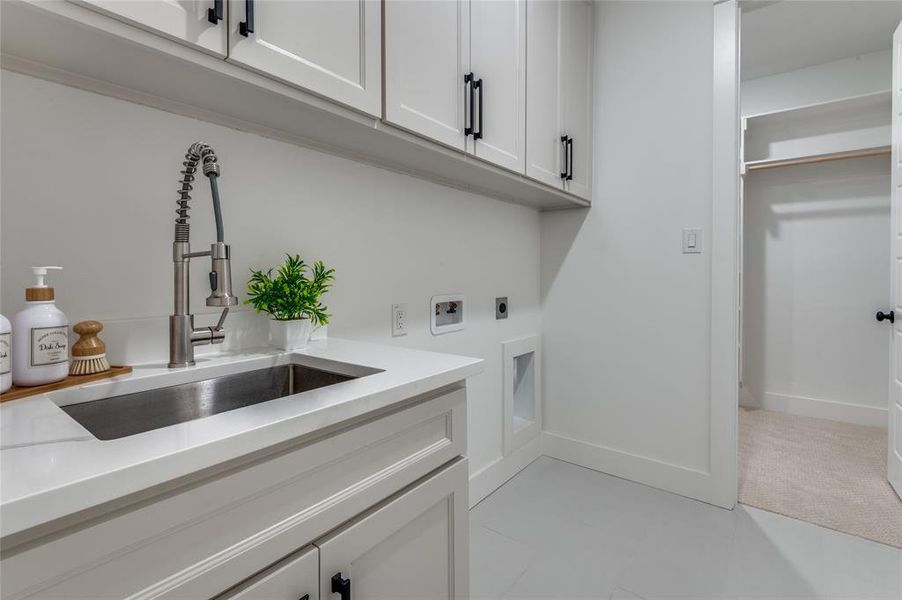 Laundry room with cabinet space, washer hookup, electric dryer hookup, and light tile patterned floors