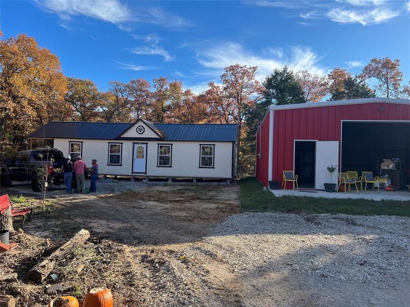 View of front of home featuring an outbuilding, metal roof, and an outdoor structure