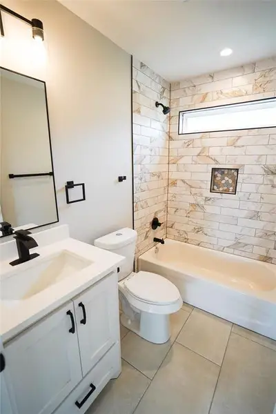 Full bath featuring vanity, shower / bath combination, and tile patterned floors