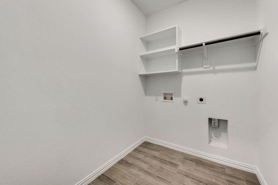 Laundry area with hookup for a washing machine, gas dryer hookup, hardwood / wood-style floors, and electric dryer hookup