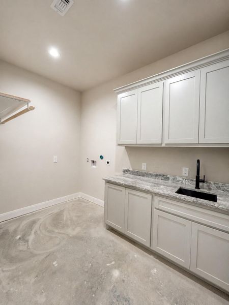 Laundry room located within the home additionally from the mudroom.