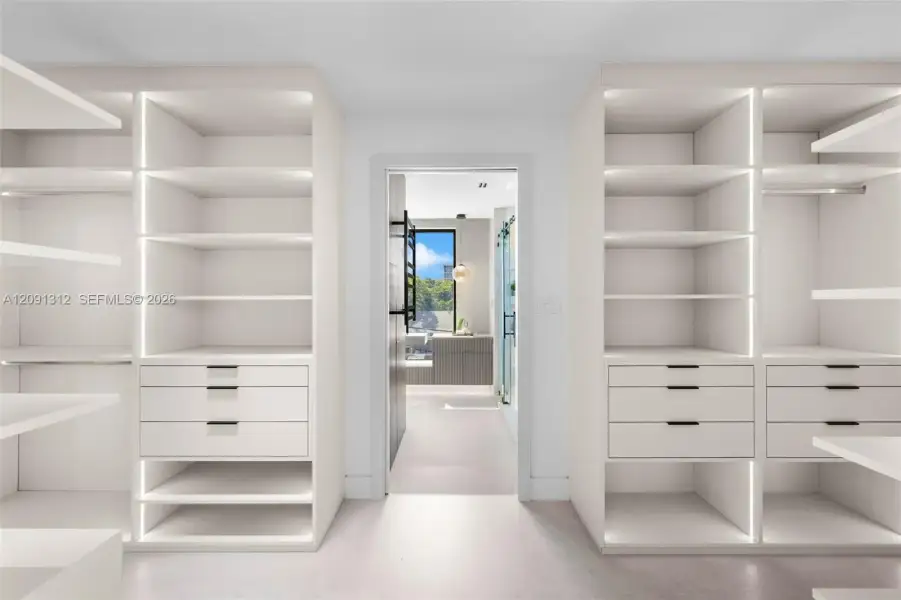 Custom floor-to-ceiling built-in cabinetry featuring integrated vertical LED lighting, matte black hardware, and soft-close drawers Custom floor-to-ceiling built-in cabinetry featuring integrated vertical LED lighting, matte black hardware, and soft-close drawers