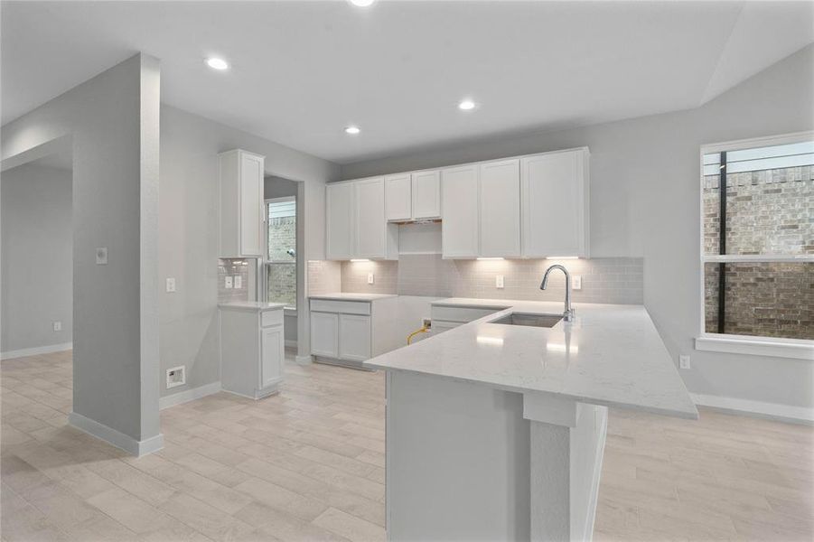 This kitchen is by far any chef’s dream! This spacious kitchen features high ceilings, stained wood cabinets, quartz countertops, SS appliances, modern tile backsplash, recessed lighting, extended counter space for breakfast bar, and a walk-in pantry all overlooking your huge family room.