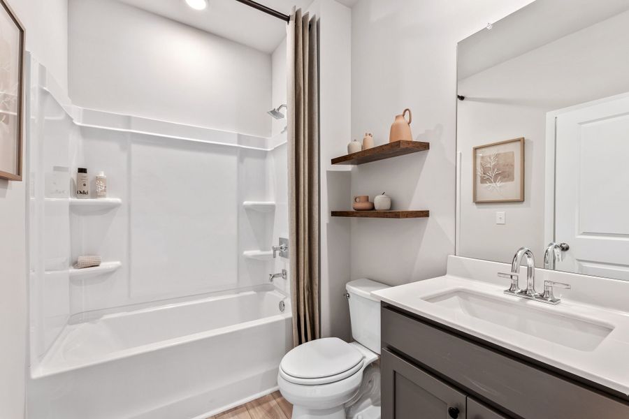 A bathroom with a tub toilet and sink. A bathroom with a tub toilet and sink.