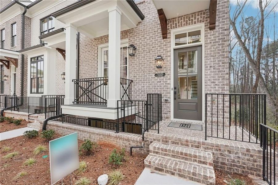 Entrance to property with brick siding and covered porch