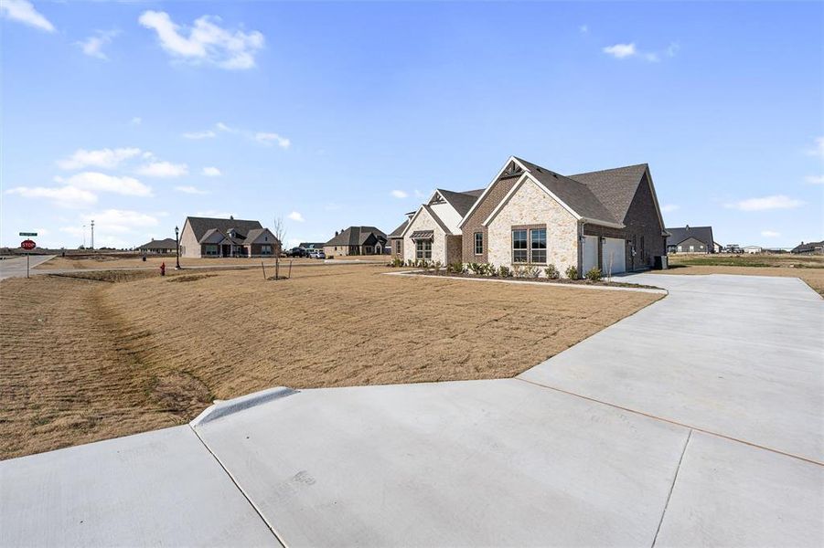 View of yard featuring driveway and a garage