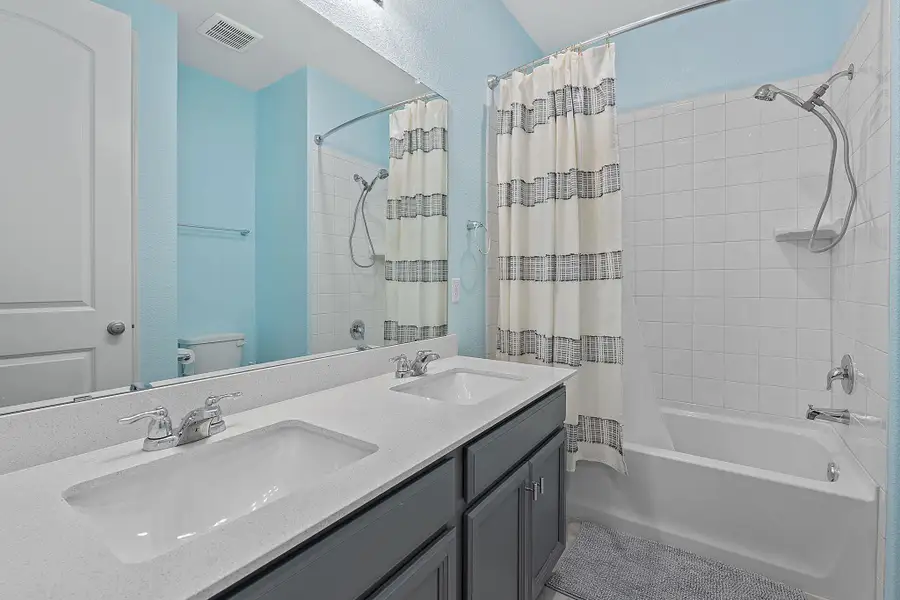 Bathroom featuring shower / bath combo with shower curtain and a sink Bathroom featuring shower / bath combo with shower curtain and a sink