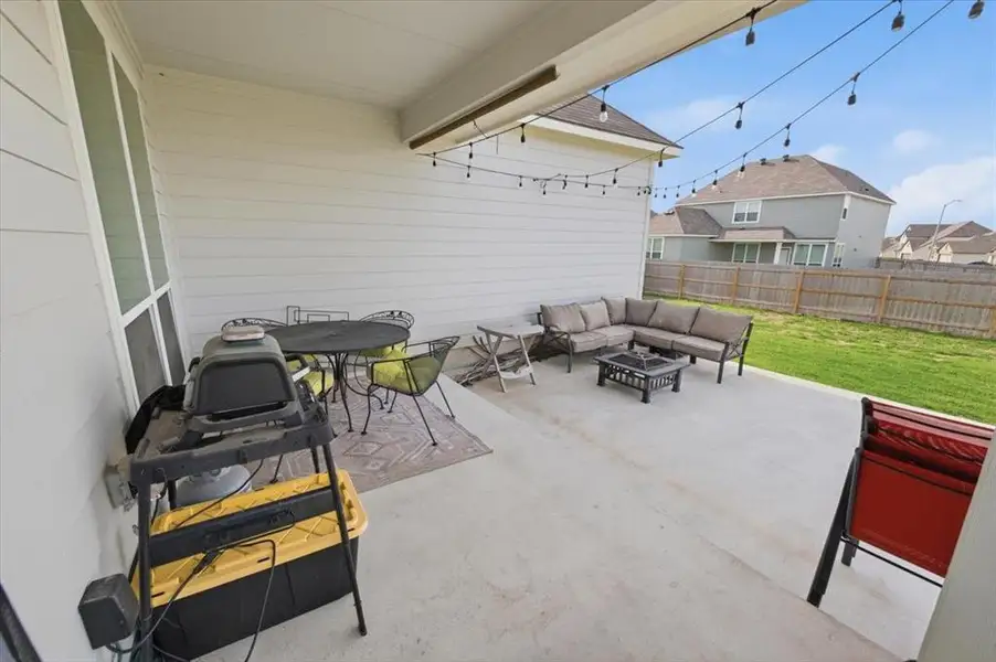 Covered back patio / terrace featuring an outdoor living space with a fire pit and seating on an extended concrete pad Covered back patio / terrace featuring an outdoor living space with a fire pit and seating on an extended concrete pad
