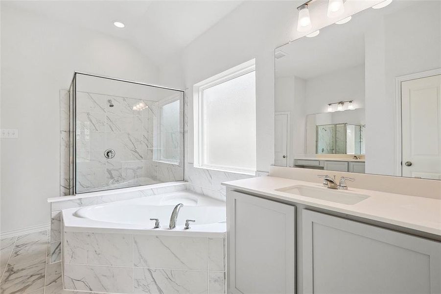 Bathroom with oversized vanity, separate shower and tub, tile floors, and lofted ceiling