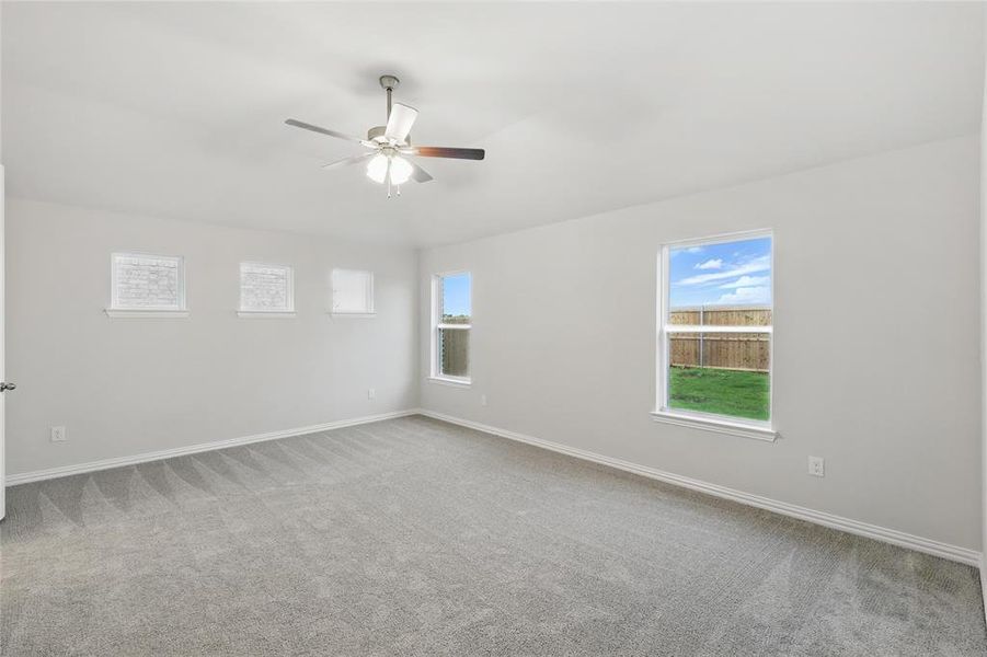 Empty room with plenty of natural light, light colored carpet, and ceiling fan Empty room with plenty of natural light, light colored carpet, and ceiling fan