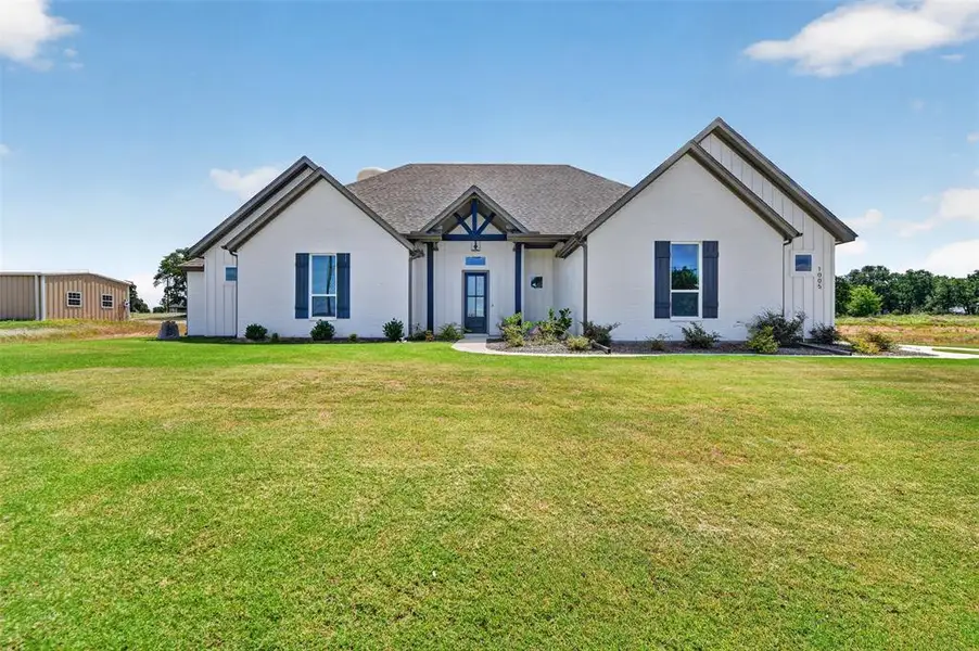 White exterior residence with dark blue trim details and window shutters White exterior residence with dark blue trim details and window shutters