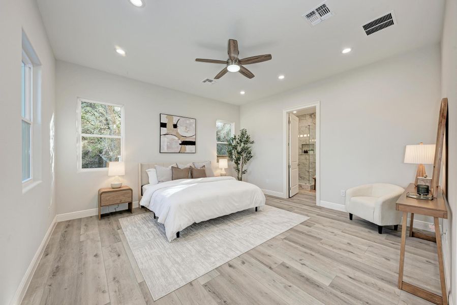 Bedroom featuring ceiling fan, light wood-style flooring, recessed lighting, and ensuite bathroom