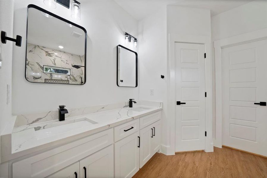Bathroom featuring double vanity and light wood-style floors