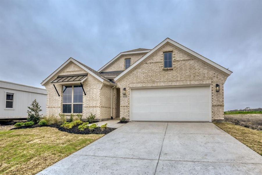 View of front of home featuring brick siding, concrete driveway, an attached garage, and a front yard