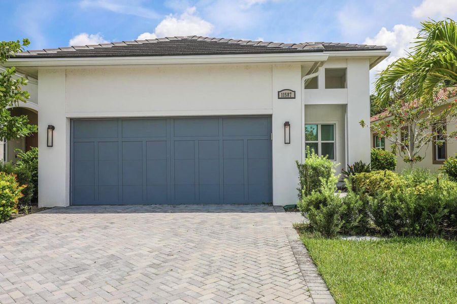 Front exterior of a new home in PGA Village Verano, Port St. Lucie, FL, highlighting curb appeal (Image 25).