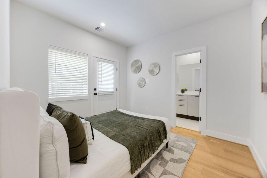 Spacious first-floor guest suite offering private outdoor access, abundant natural light, hardwood flooring, and an en-suite bath—perfect for guests, roommates, or a home office setup.