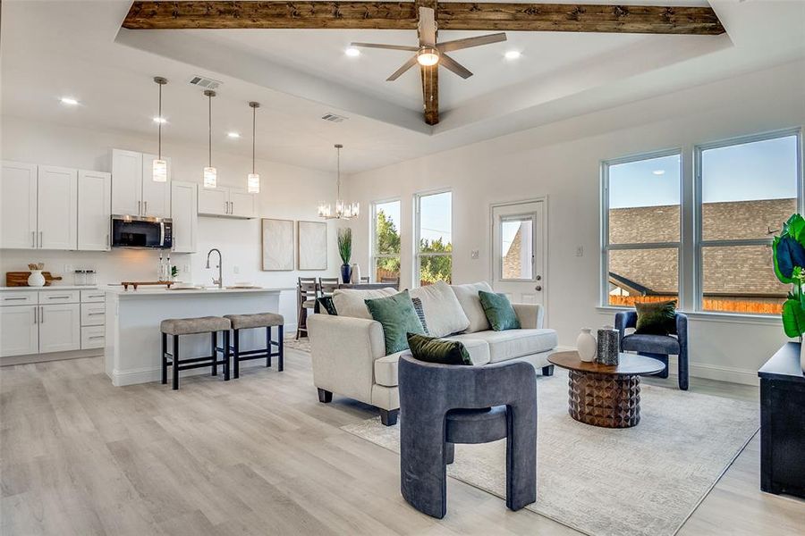 Living area featuring recessed lighting, a ceiling fan, light wood-style flooring, plenty of natural light, and a chandelier Living area featuring recessed lighting, a ceiling fan, light wood-style flooring, plenty of natural light, and a chandelier