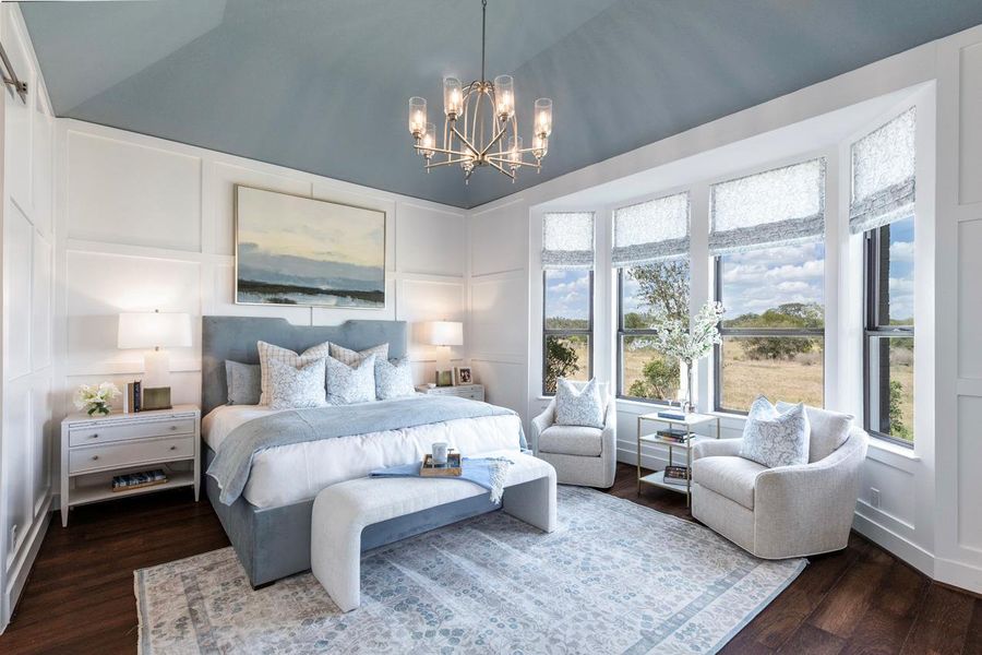 Bedroom with a decorative wall, a notable chandelier, vaulted ceiling, and dark wood finished floors Bedroom with a decorative wall, a notable chandelier, vaulted ceiling, and dark wood finished floors