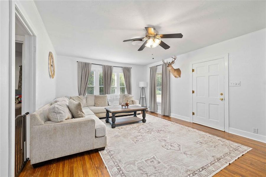 Living area with wood finished floors and a ceiling fan Living area with wood finished floors and a ceiling fan