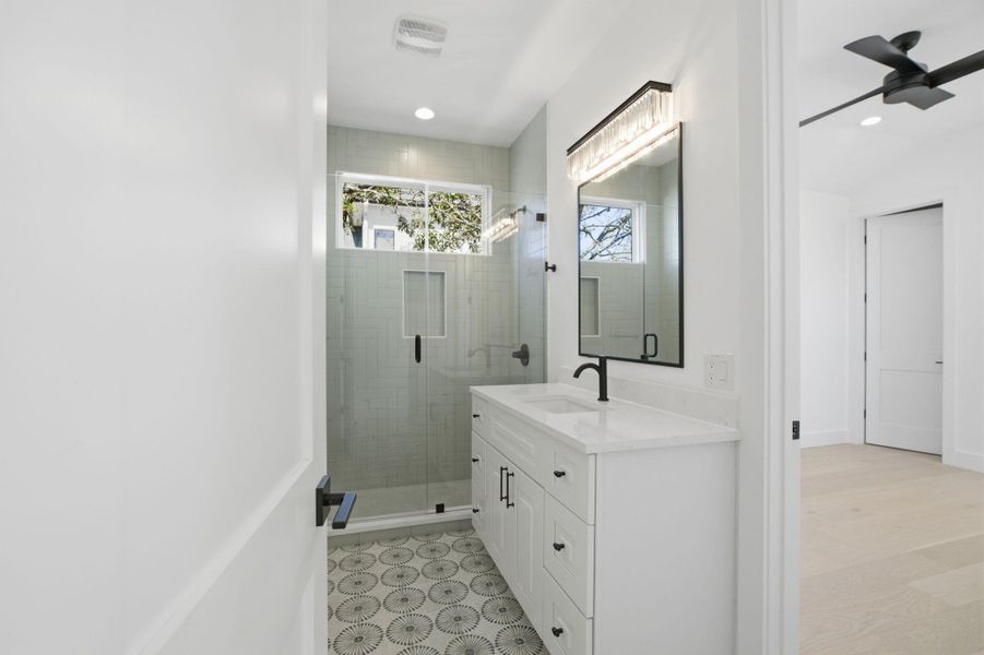 Full bathroom featuring vanity, ceiling fan, a stall shower, and recessed lighting