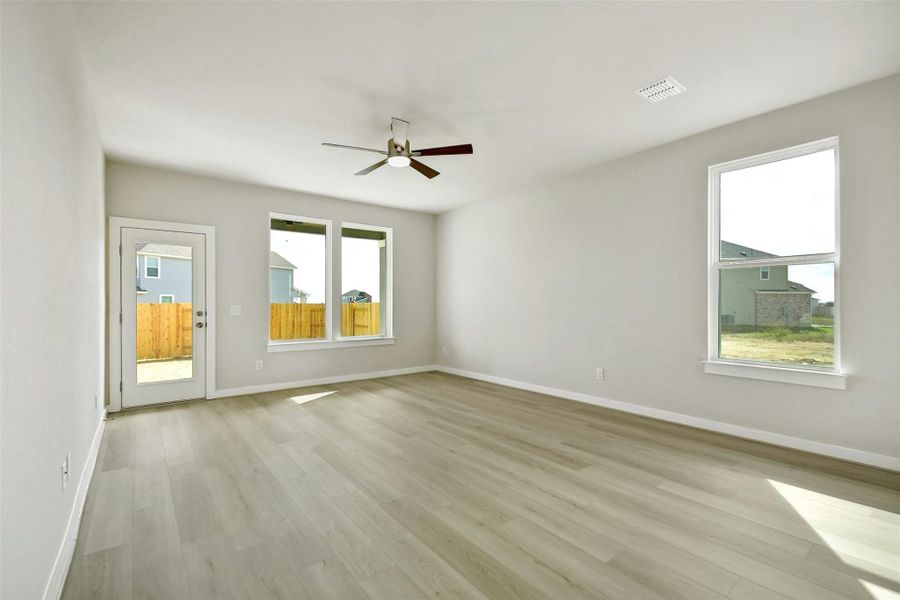 Empty room with ceiling fan and light hardwood / wood-style flooring