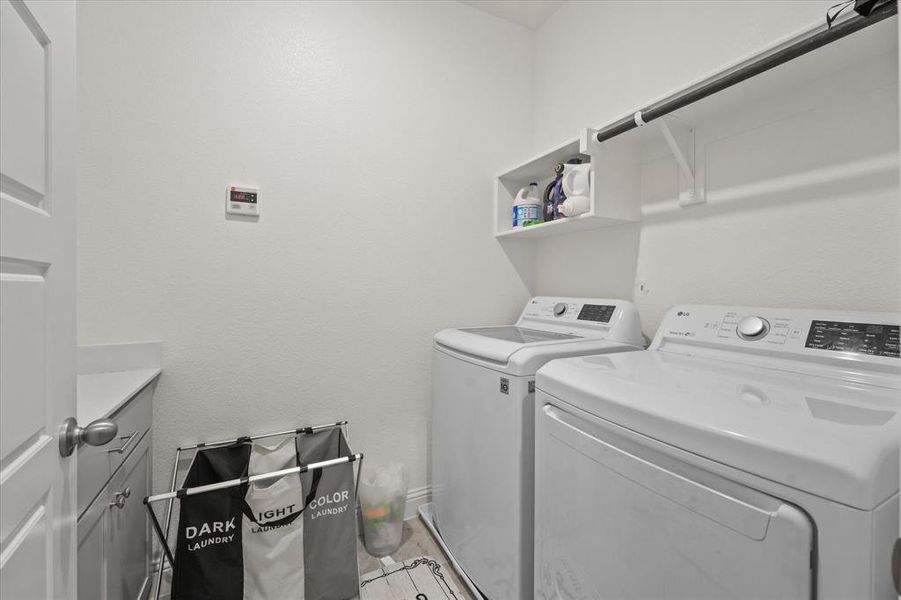 Clothes washing area with cabinets and washer and clothes dryer